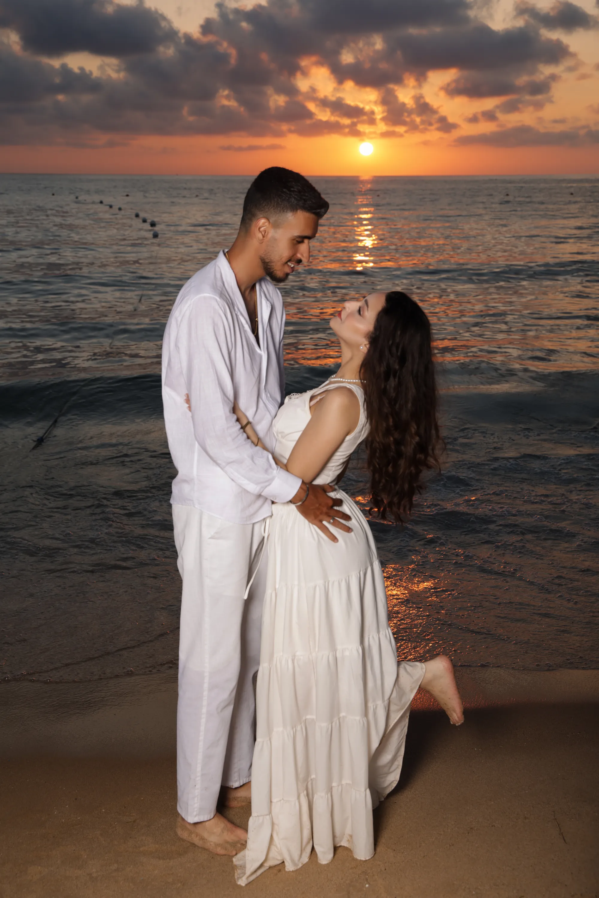 Couple embracing on the shore at sunset